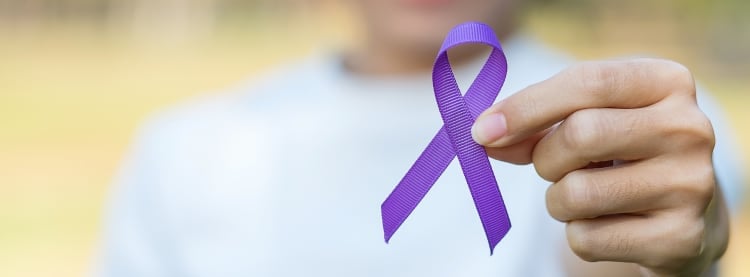 Person holding Fibromyalgia purple ribbon badge