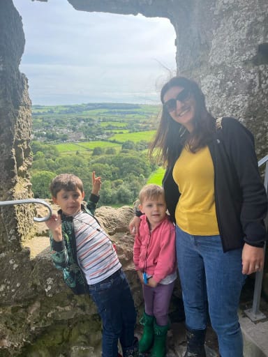 Breathworks Mindfulness Teacher, Stanislava Try, with her family leaning against a rock overseeing a beautiful English countryside
