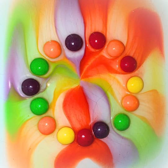 A beautiful colourful pattern where skittles have been soaked with hot water
